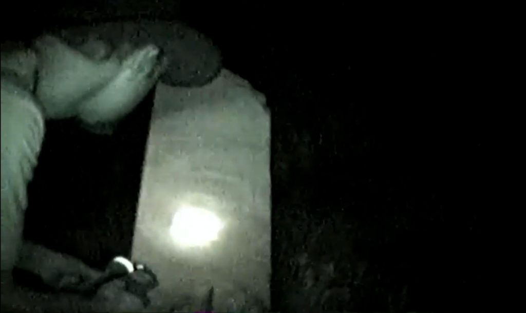 Cody Polston of the Southwest Ghost Hunters Association examines one of the tombstones during his group's investigation at Dawson Cemetery. (Photo courtesy of Cody Polston)