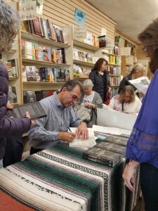 Nick Pappas signs copies of his book, "Crosses of Iron: The Tragic Story of Dawson, New Mexico, and Its Twin Mining Disasters," on Nov. 11 at Treasure House Books & Gifts in Albuquerque. (Photo by Susan Pappas)